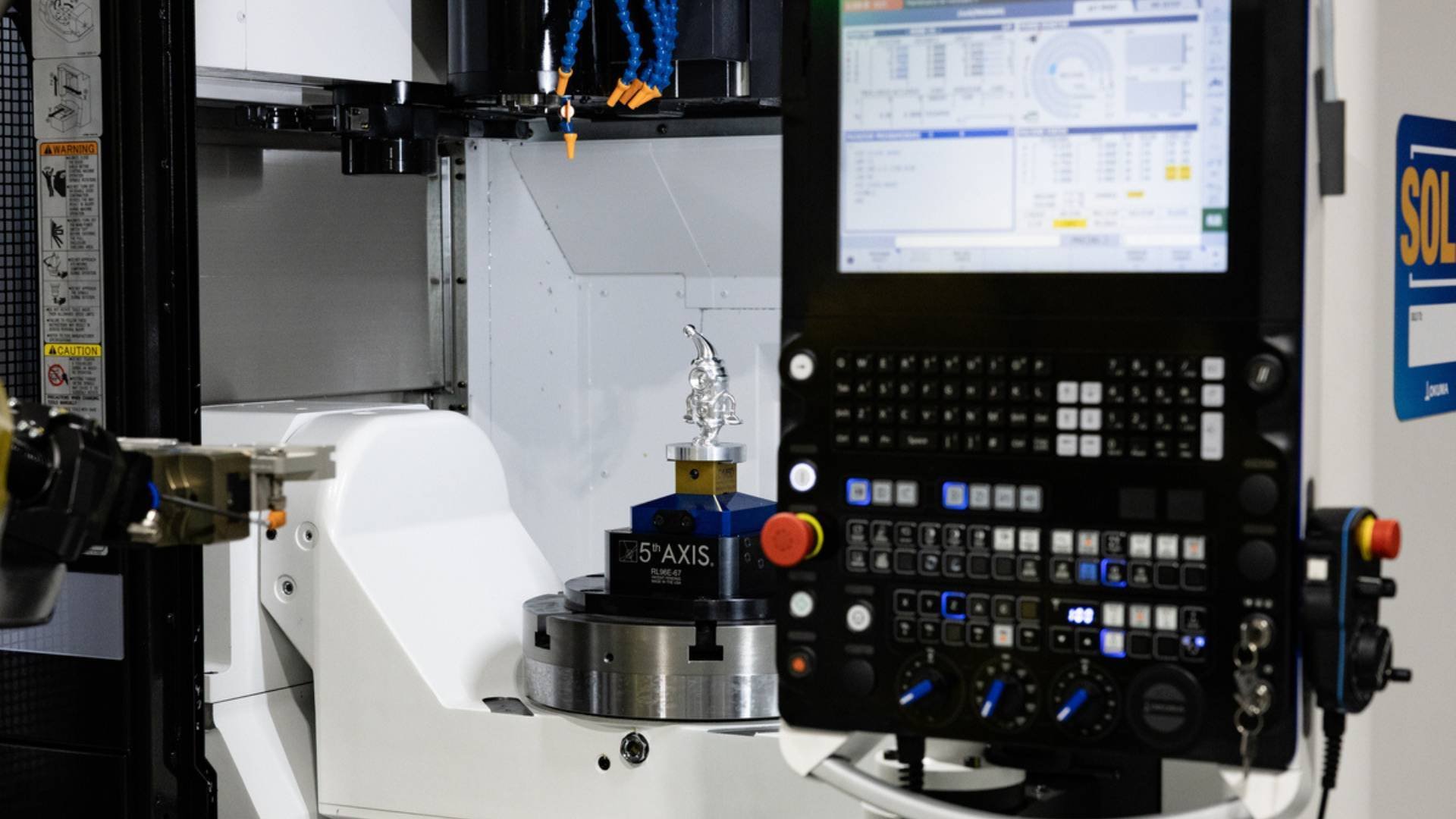 Completed 5-axis part inside 5-axis machining center with intricate part design