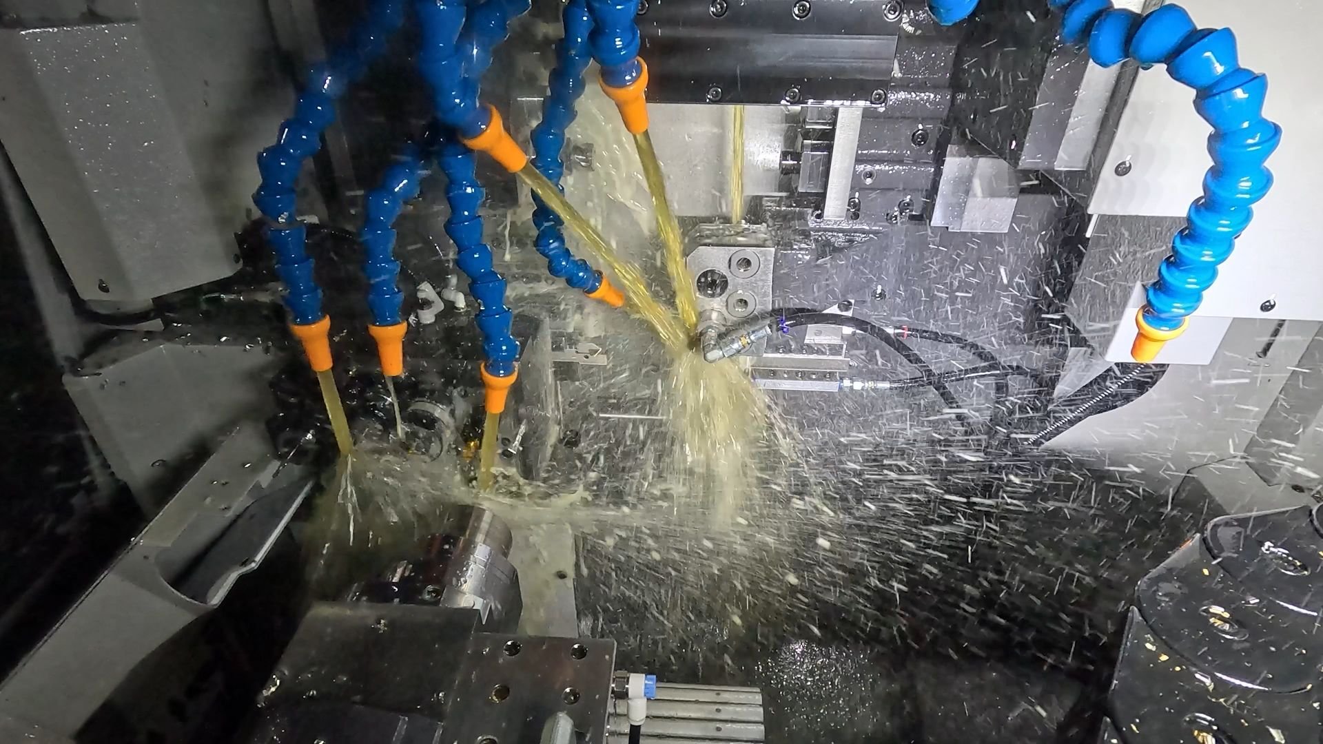 CNC Swiss machining in process with high-pressure coolant and multi-axis tooling on a Tsugami lathe producing precision small diameter parts